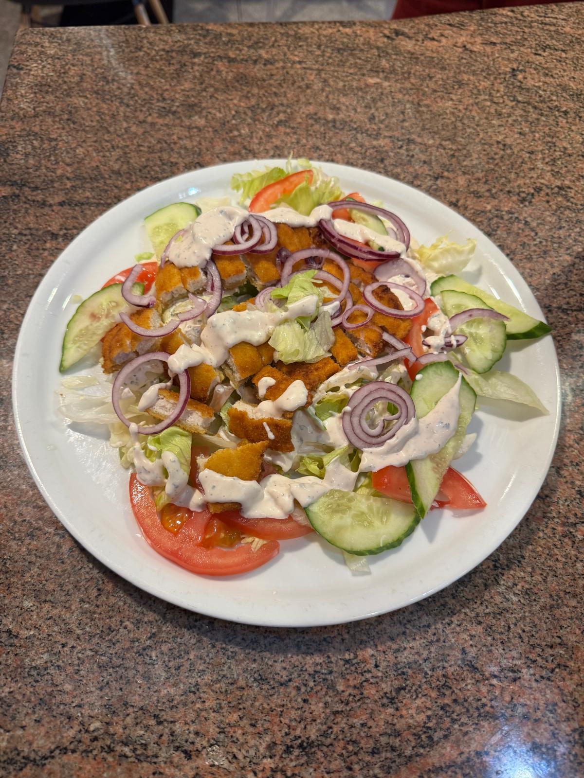 Schnitzel Salat – Eisbergsalat, Tomate, Gurke, Zwiebel und Putenbruststreifen mit Sauce